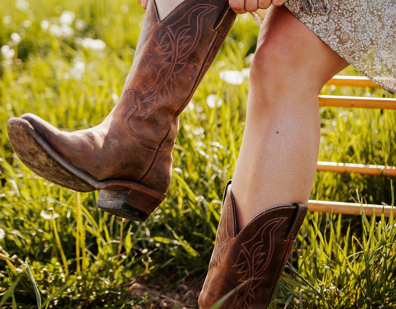 woman putting on cowboy boots